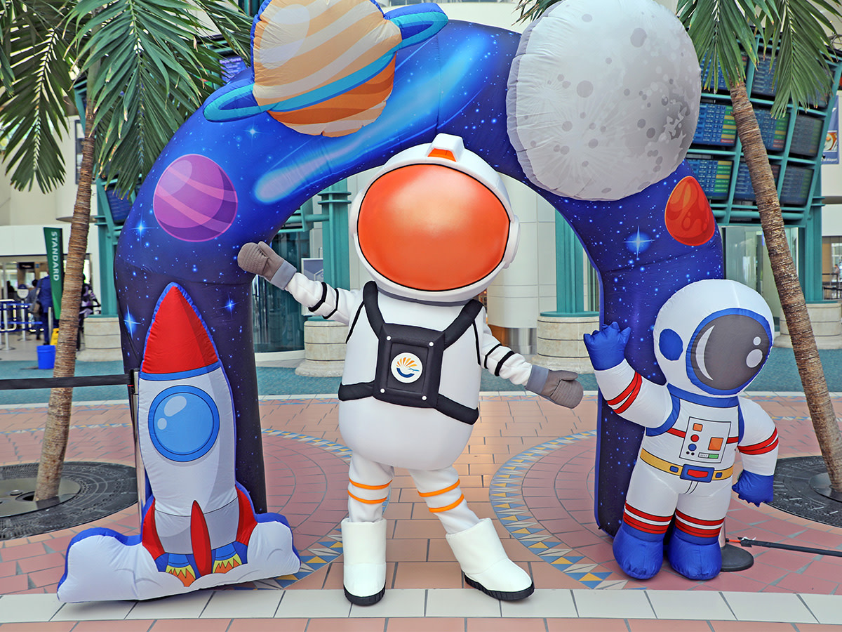 Annie the Astronaut standing in front of a blow up space arch.