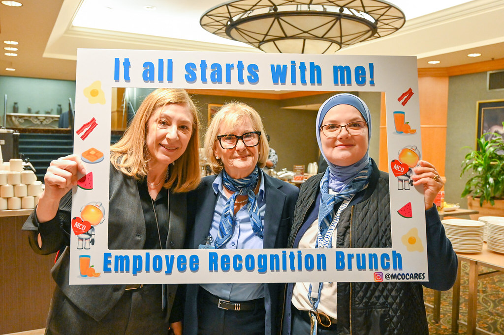 January 2024 Employee Recognition Brunch. Photo of three GOAA employees holding a large frame in front of them. The frame says, "It all starts with me!"