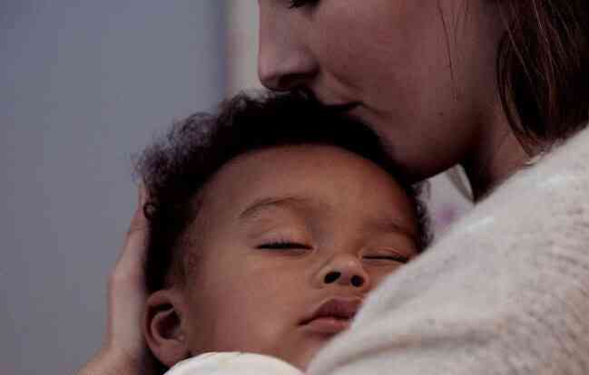 Madre con niño dormido en brazos