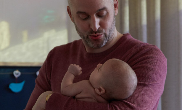 dad putting newborn to sleep