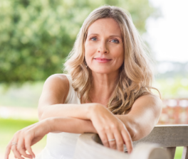 A woman sitting on a bench smiling for the photograph