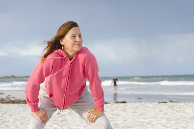 woman warming up to exercise on the beach