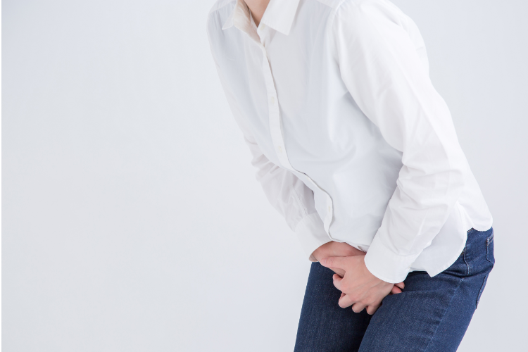 A woman clutching her bladder due to incontinence