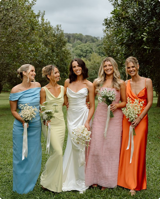 four bridesmaids and a bride stand holding flowers