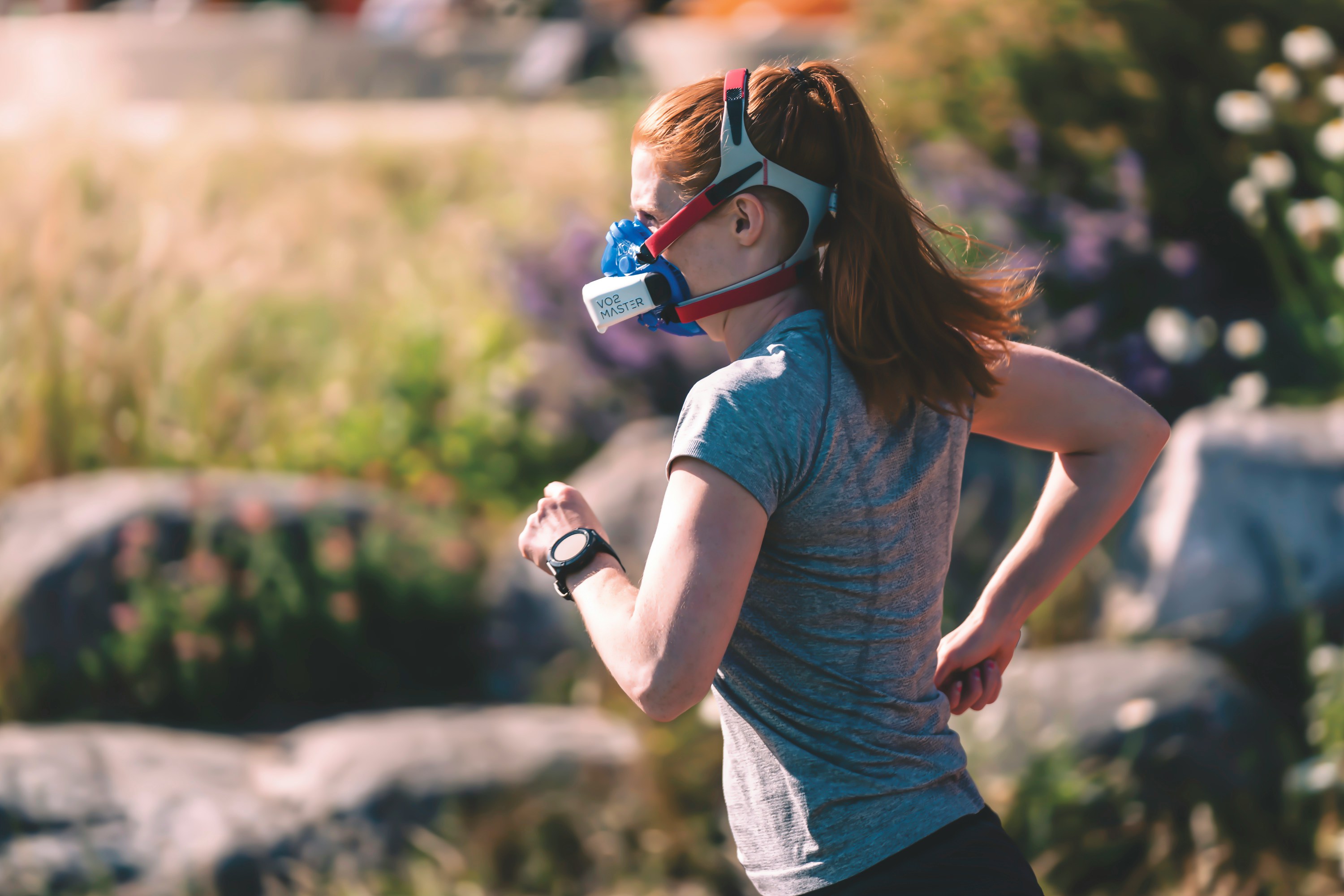 A woman wearing a vo2 testing max mask on a run