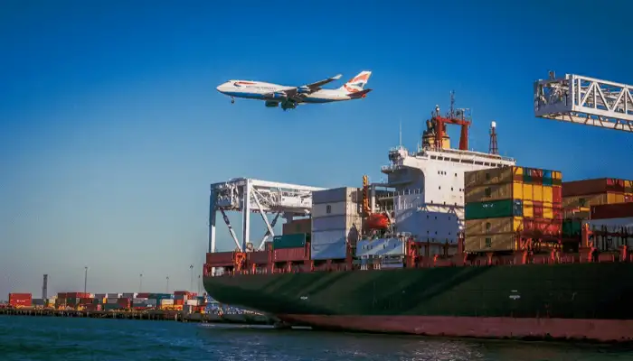 Image of a plane flying above a shipping dock