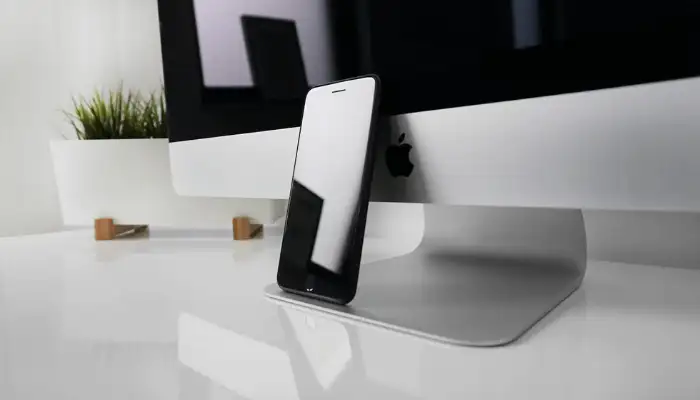 iphone propped up against a computer monitor