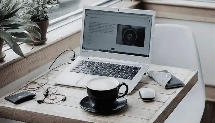 Image of a laptop in a coffee shop showing a startup website