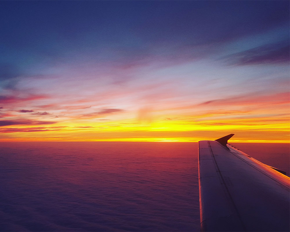 a plane's wing in a sunset