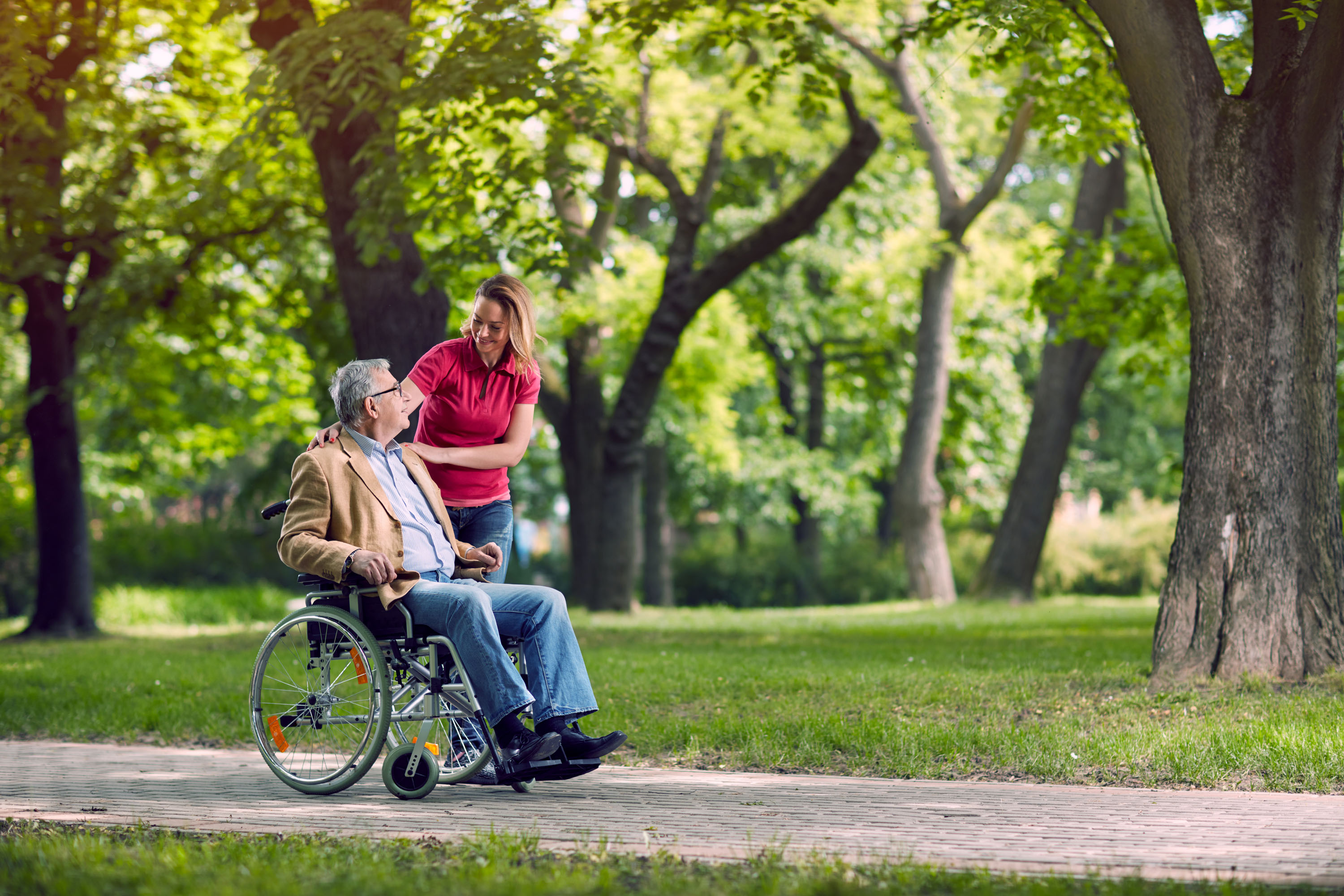 A nurse pushing a man in a wheel chair