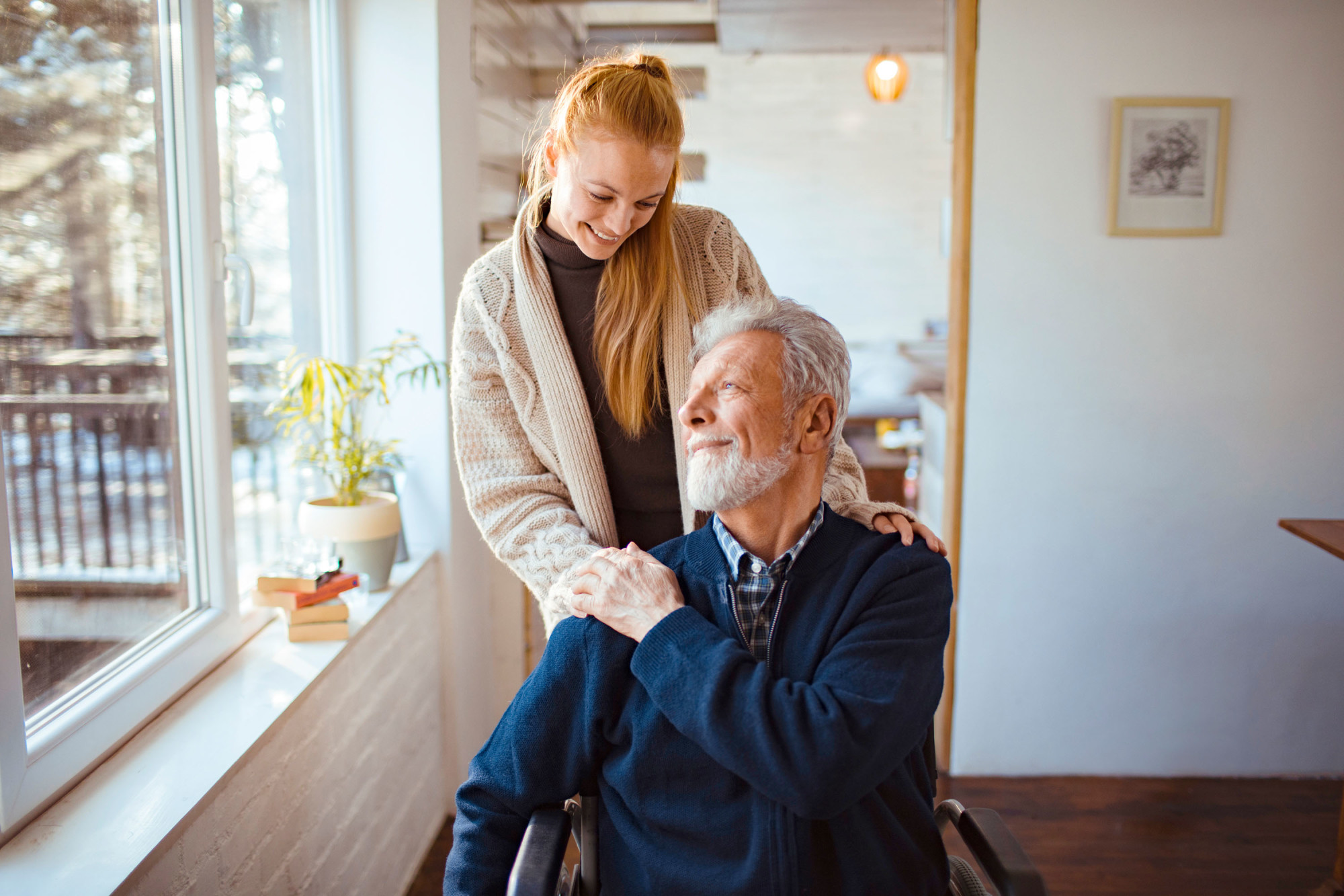 A woman comforting a man in a wheelchair