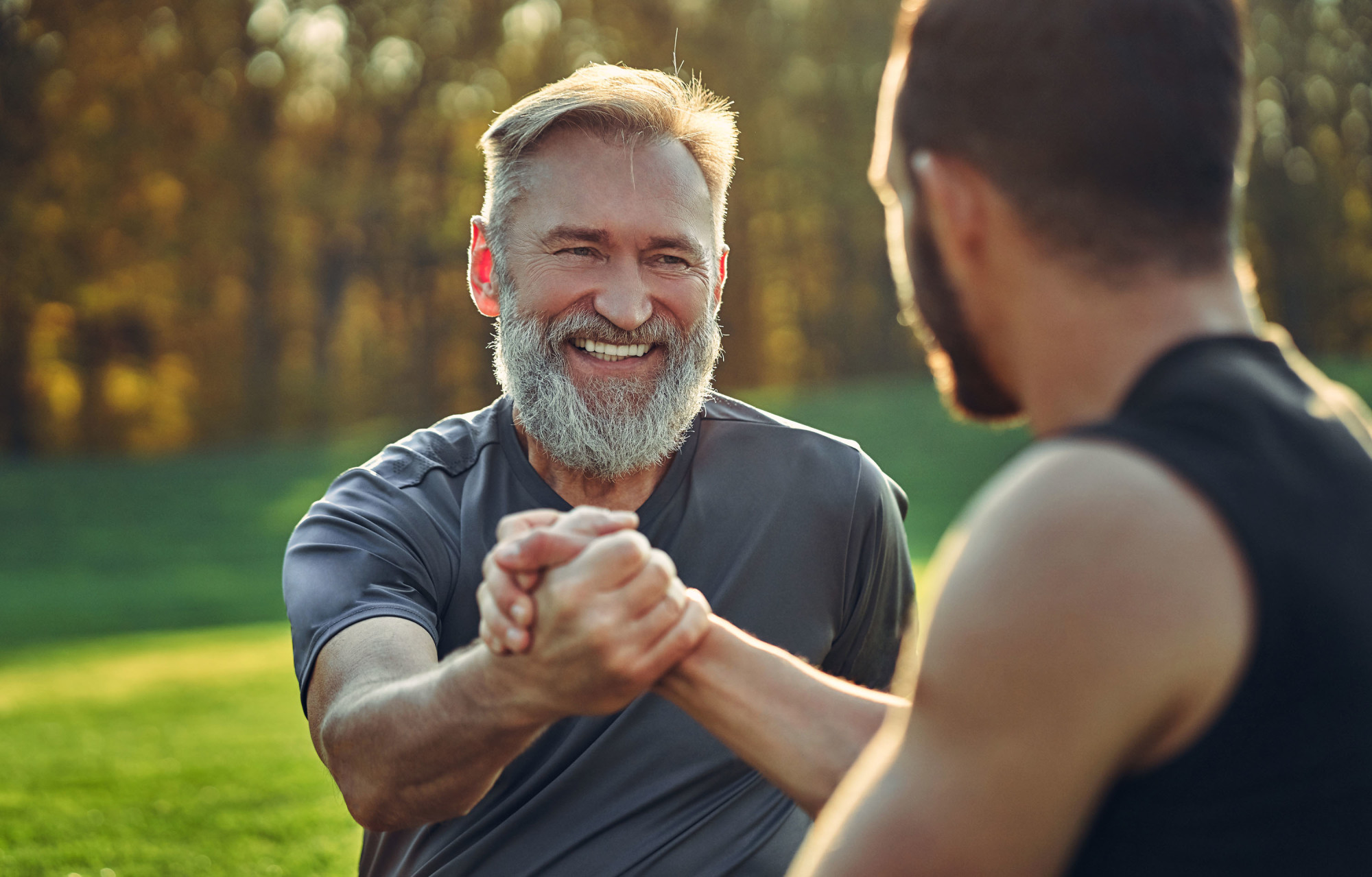 Two men shaking hands while working out