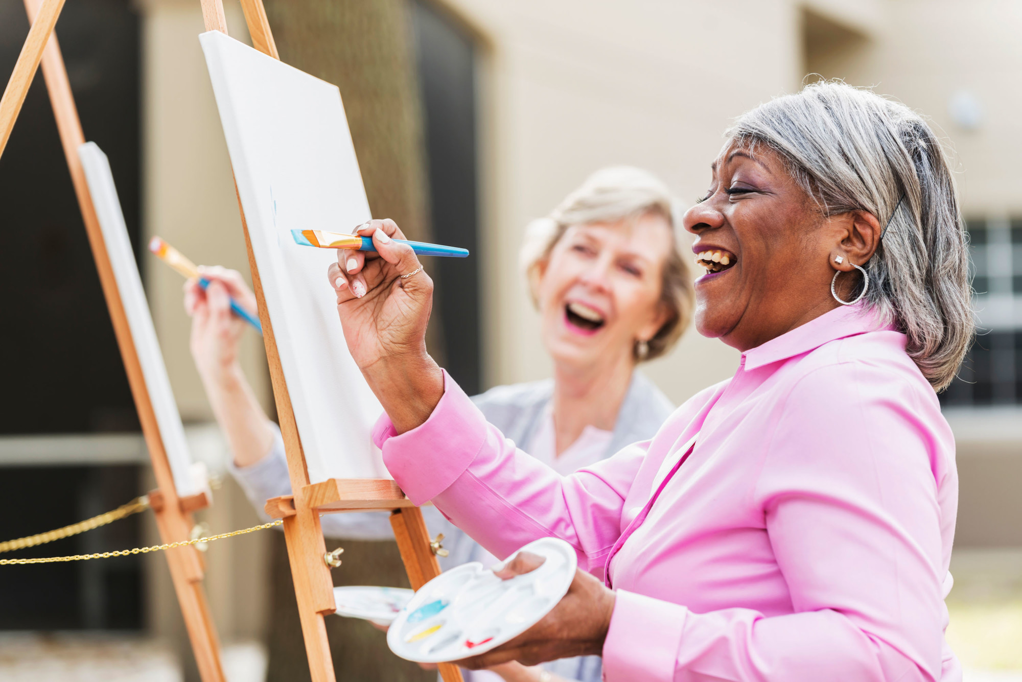 Two women painting and smiling