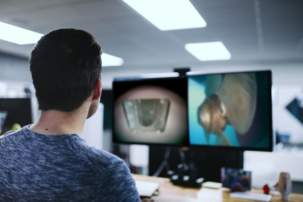 Employee remotely watching an underwater survey of a vessel