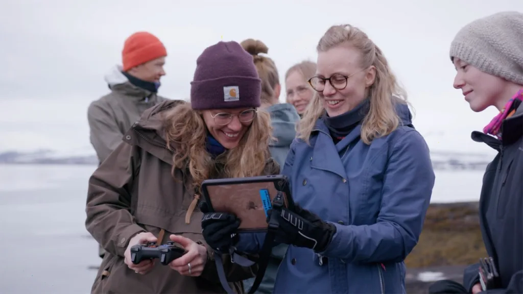 Studenter på UiT ser på undervannsbilder fra en Blueye drone på en ipad
