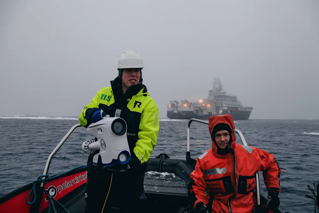 Martin og en av forskerne i en båt sammen med undervannsdronen Blueye Pioneer
