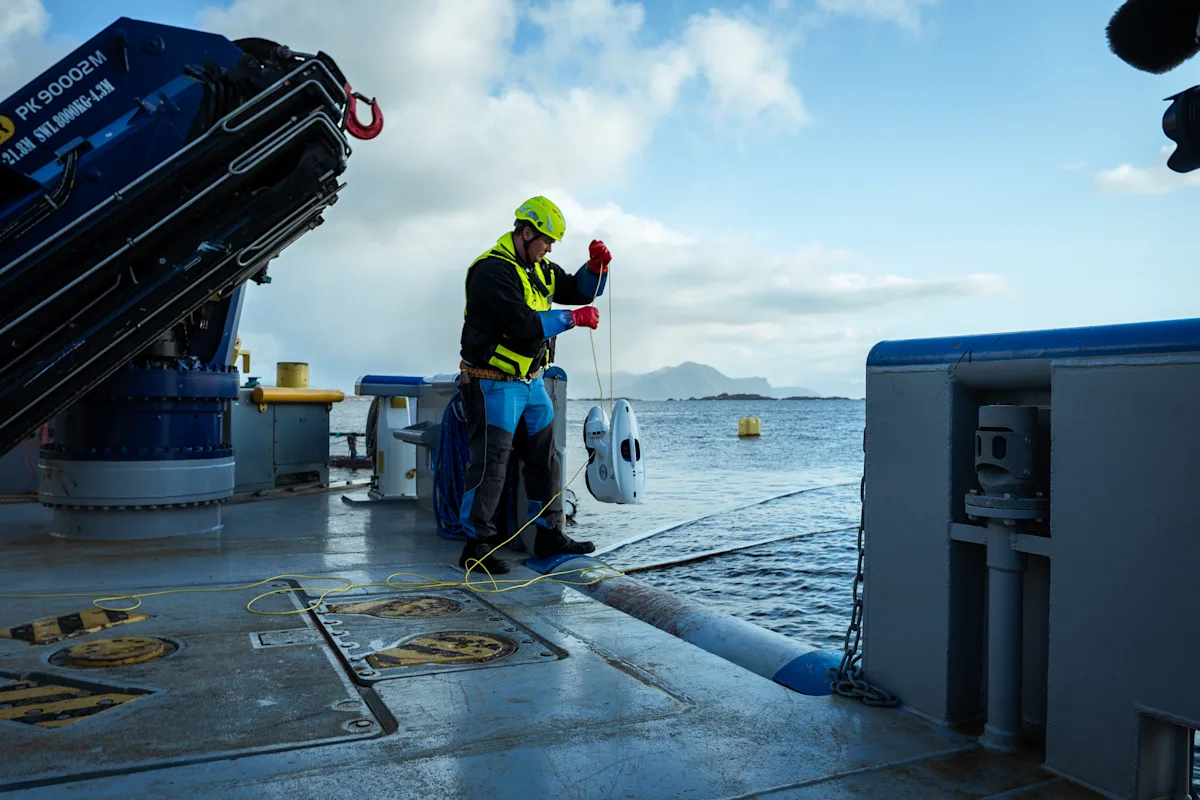 Operator at the pen launches the underwater drone