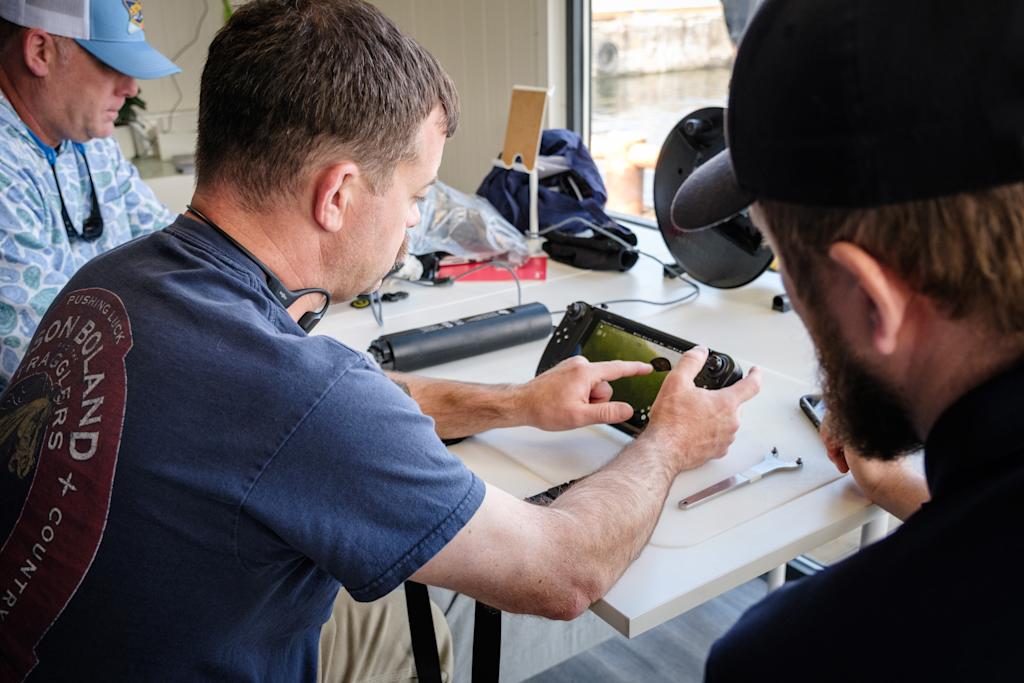 Nærbilde av hender som jobber med en komponent på Blueye X3