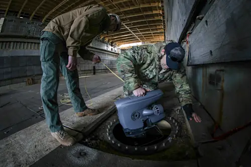 PHILADELPHIA, Pa. — A U.S. Navy Diver from Mobile Diving and Salvage Unit (MDSU) 2 and a Navy Explosive Ordnance Disposal (EOD) Technician from Explosive Ordnance Disposal Mobile Unit (EODMU) 6 deploy a Remote Operated Vehicle (ROV) in a ballast tank of the ex-USS Fort McHenry (LSD-43), Philadelphia, Pennsylvania, Nov. 19, 2024. MDSU 2 and Explosive Ordnance Disposal Mobile Unit (EODMU) 6 are training as an integrated team during a simulated afloat salvage exercise encompassing battle damage, unexploded ordnance (UXO) and long-range communication aboard the ex-USS Fort McHenry. (U.S. Navy photo by Mass Communications Specialist 2nd Class Jackson Adkins)