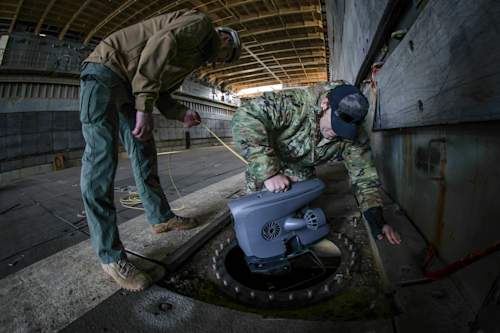 PHILADELPHIA, Pa. — A U.S. Navy Diver from Mobile Diving and Salvage Unit (MDSU) 2 and a Navy Explosive Ordnance Disposal (EOD) Technician from Explosive Ordnance Disposal Mobile Unit (EODMU) 6 deploy a Remote Operated Vehicle (ROV) in a ballast tank of the ex-USS Fort McHenry (LSD-43), Philadelphia, Pennsylvania, Nov. 19, 2024. MDSU 2 and Explosive Ordnance Disposal Mobile Unit (EODMU) 6 are training as an integrated team during a simulated afloat salvage exercise encompassing battle damage, unexploded ordnance (UXO) and long-range communication aboard the ex-USS Fort McHenry. (U.S. Navy photo by Mass Communications Specialist 2nd Class Jackson Adkins)