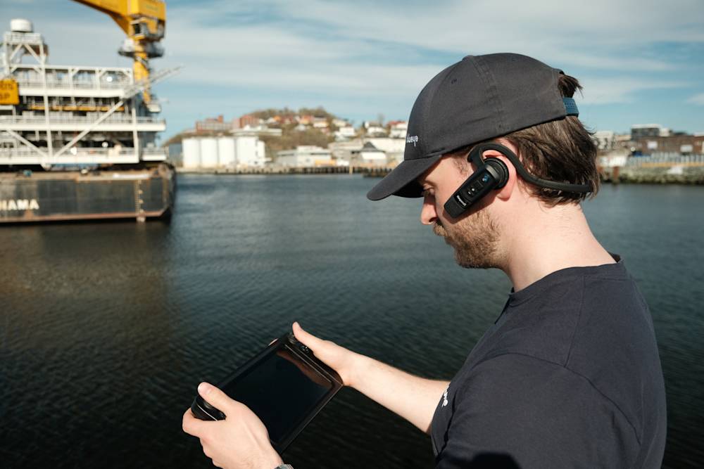 Blueye ROV operator with rugged controller and headset with platform in the background
