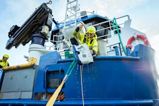 Røkter henter opp drone fra båten