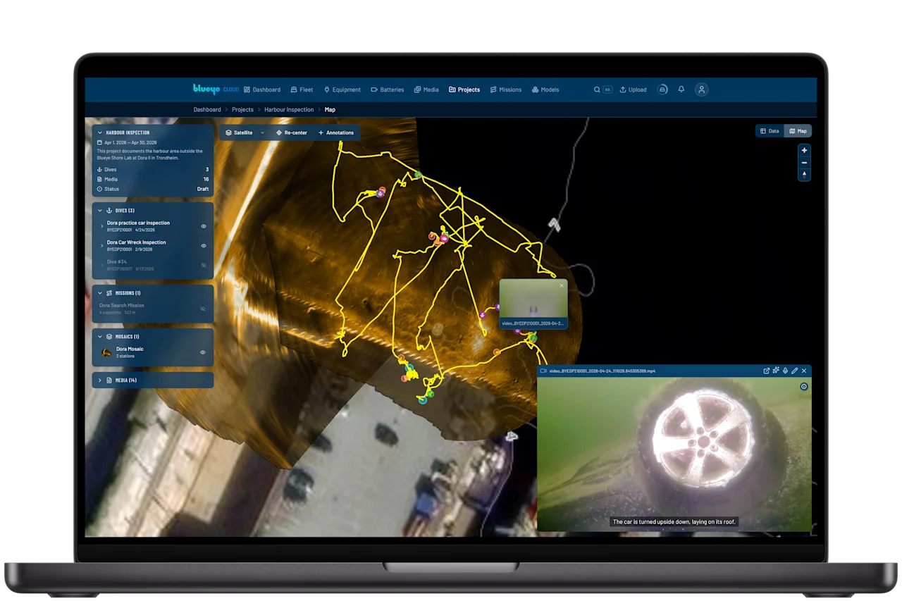 A Blueye Cloud project map showing dive tracks drawn over the sonar mosaic at Dora, with the dive video of a submerged car playing alongside