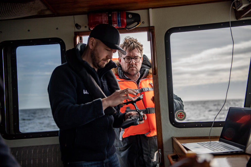 Trond Larsen og Expressen reporter ser på en smarttelefon og controller på eksplosjonsstedet Nord Stream