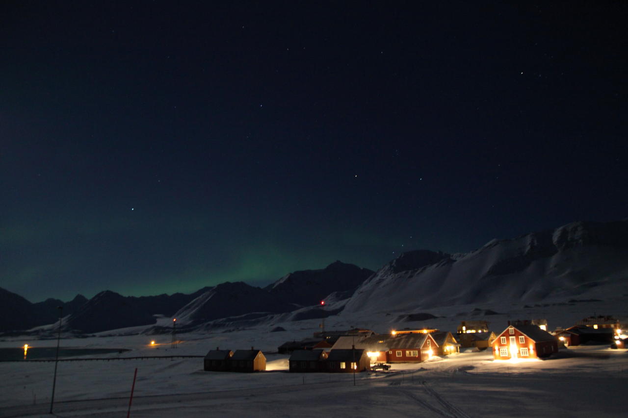 Ny Ålesund with aurora borealis in the background