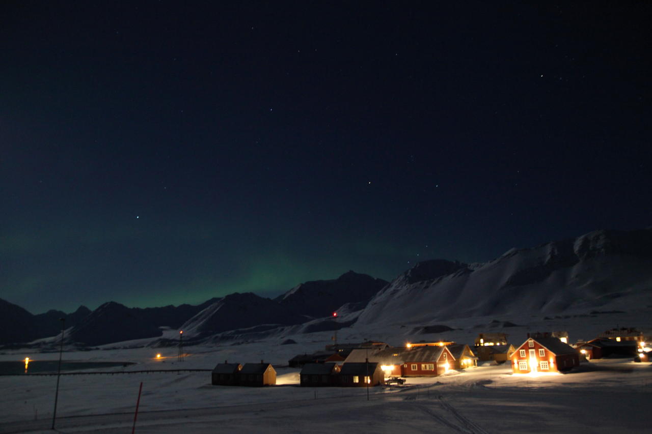 Ny-Ålesund med nordlyset i bakgrunnen