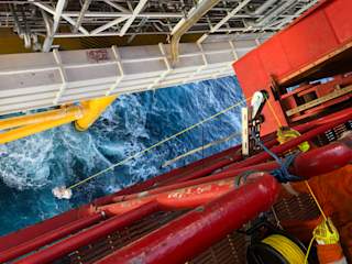 Lowering drone from drilling jackup-rig by hand