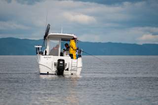 Fisherman fishing from back of boat