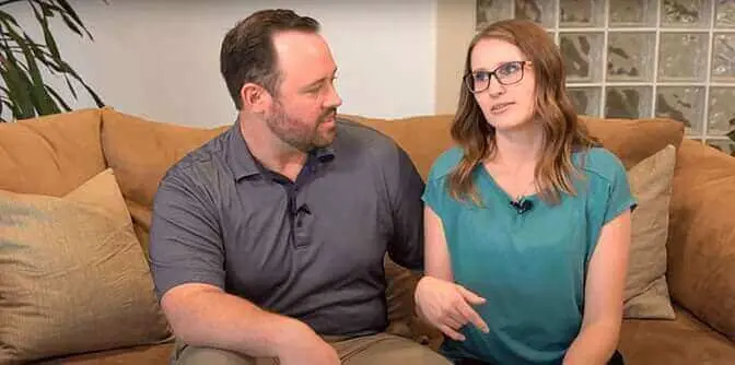 A man and woman sitting on a couch.