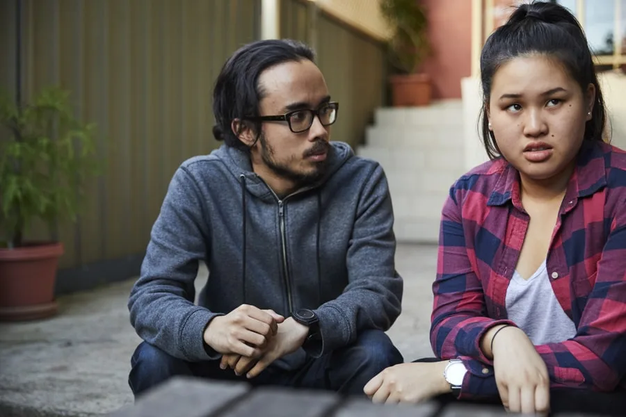 boy consoling girl sitting down