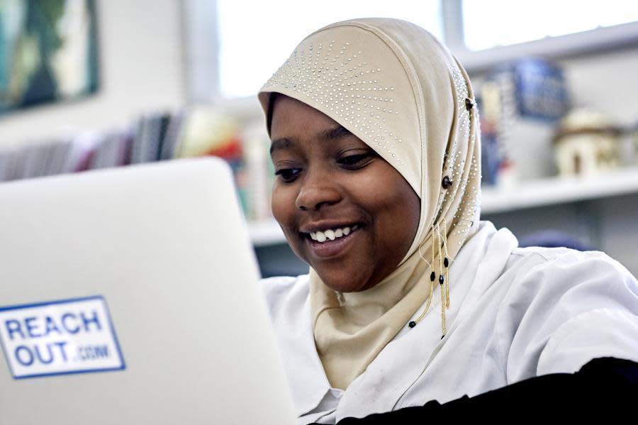 160301_024_student smiles at laptop in classroom