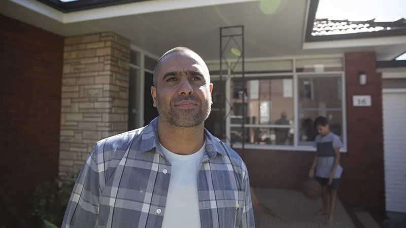 father standing outside house