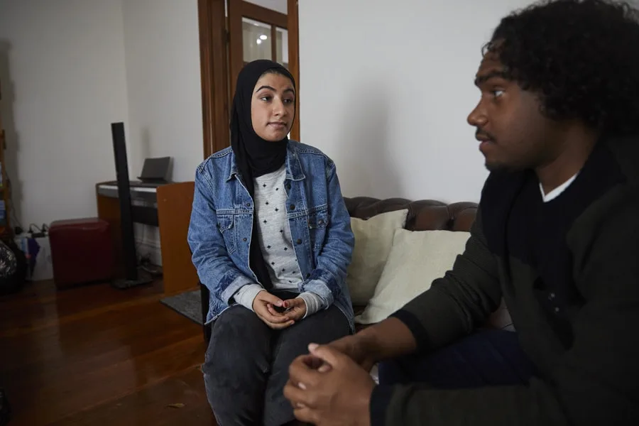 Girl and boy sitting on couch speaking