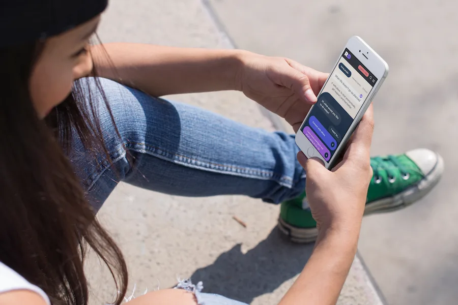 Young girl sitting down using phone