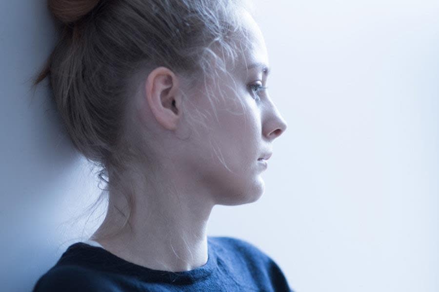 Girl looking sad with white wall