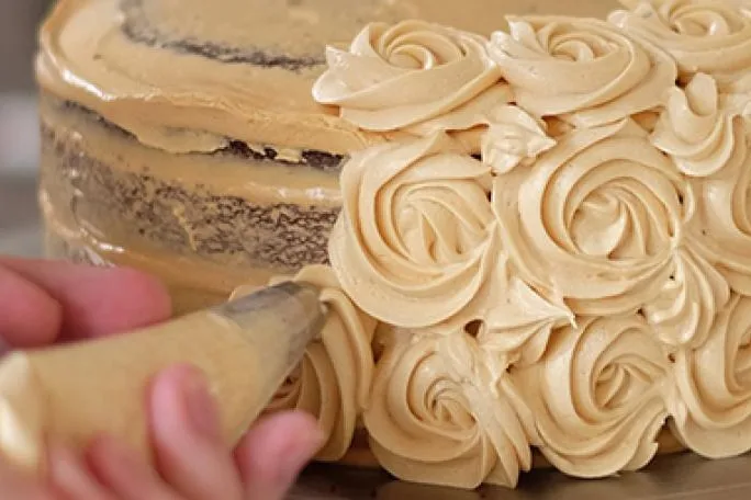 Image of a person icing a cake.