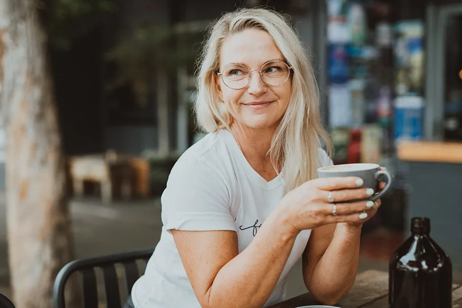 Jayne McCartney sitting down and drinking coffee