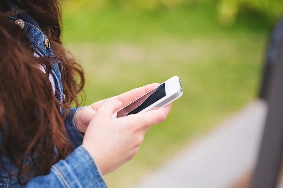 teenage girl holding mobile phone