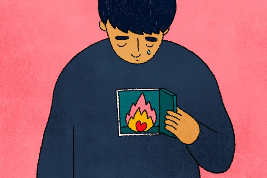 A teen boy is smiling with his eyes looking down. A tear drop is running down his face. He is opening a small door to his chest, which has a small heart surrounded by flames within. 