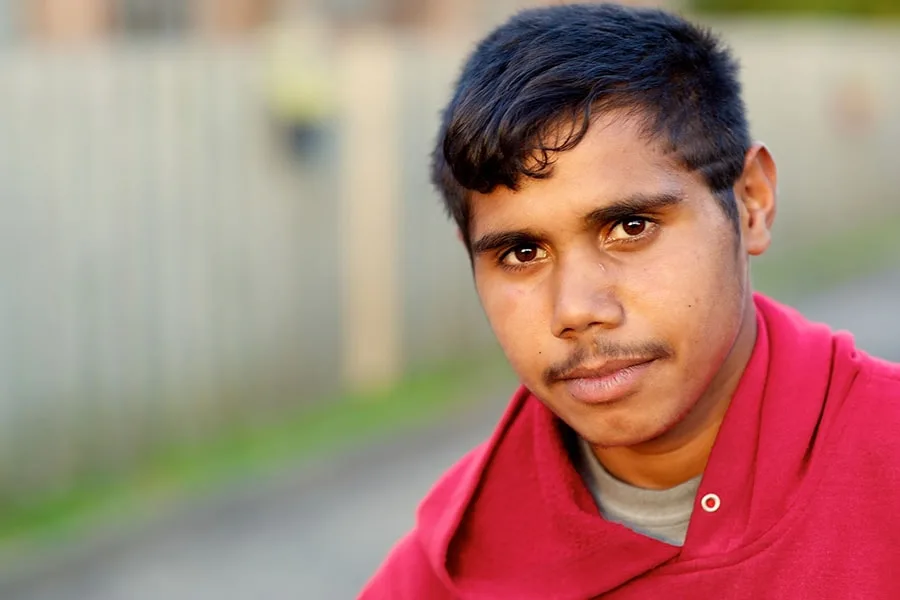 Young man wearing red hoodie looking at camera