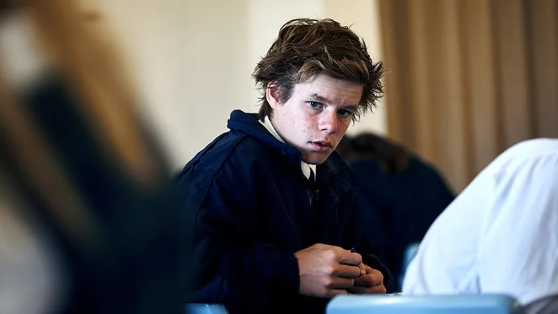 a boy in school uniform looking concerned