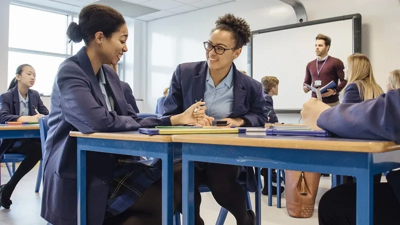 Two female students chatting in class