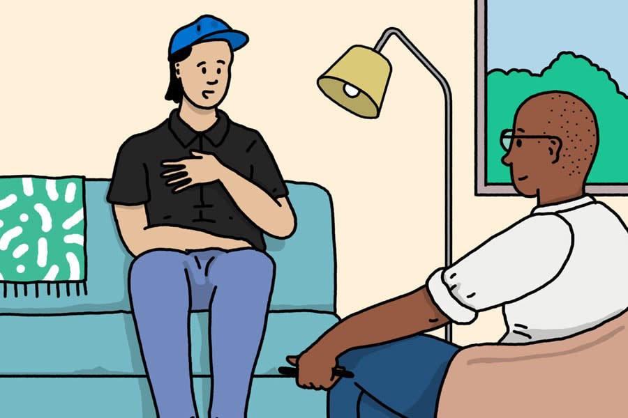 young man sits on couch talking to a mental health professional