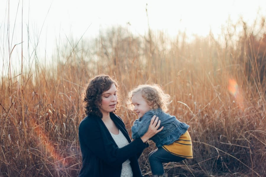 Woman in black cardigan holding baby