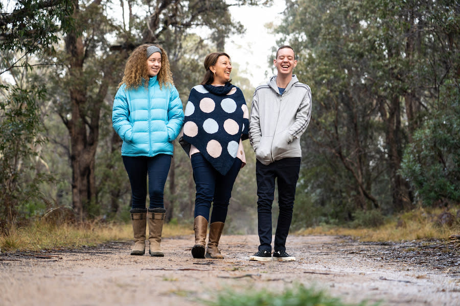 Image of a mother and two teens going on a bush walk. The teenage girl and the mother are laughing while looking left towards the teenage boy, who is laughing loudly.