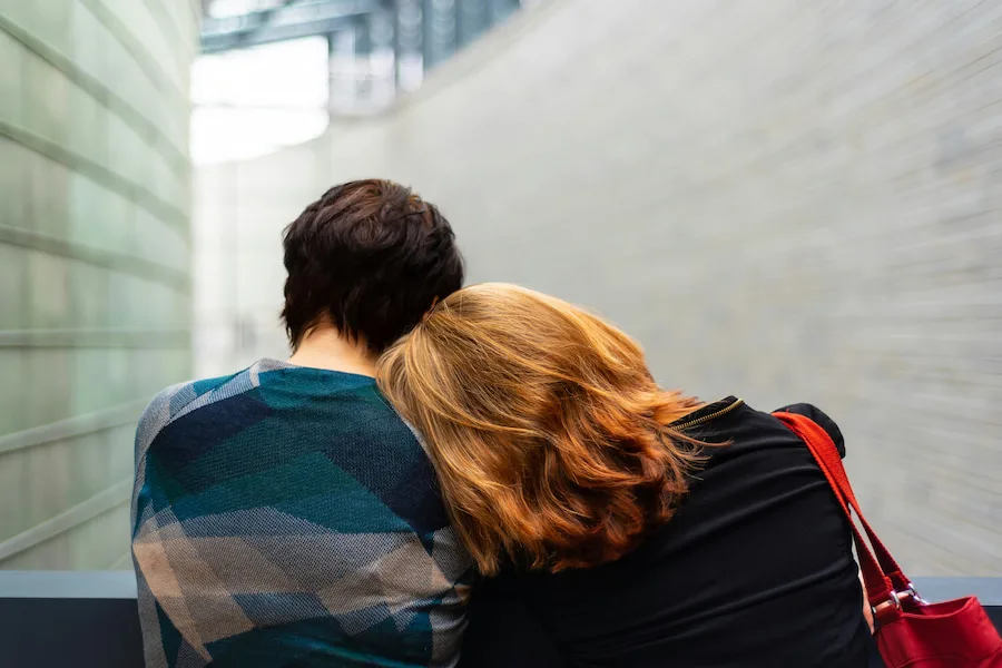 Young couple leaning on each other looking away from camera